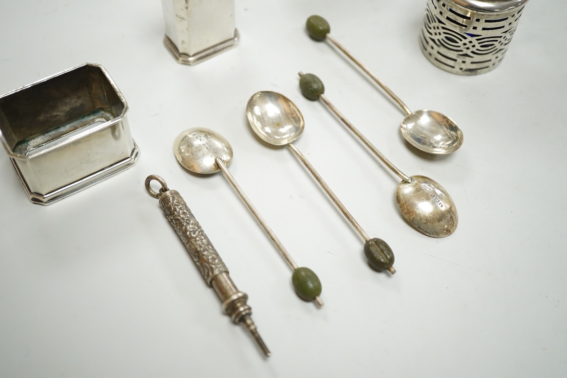 A George V silver three piece condiment set by Mappin & Webb, Birmingham, 1927(two lacking liners), together with one other silver mustard pot, four silver bean end coffee spoons and a white metal propelling pencil.